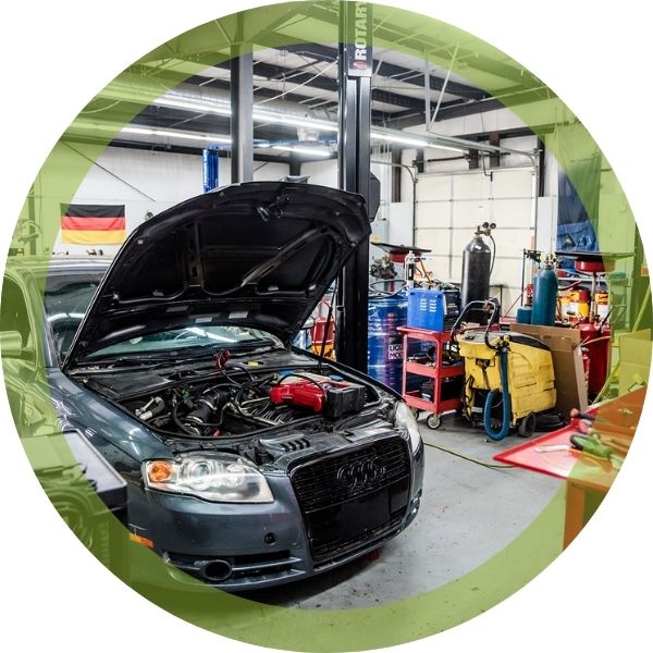 A vehicle with its hood up in a shop