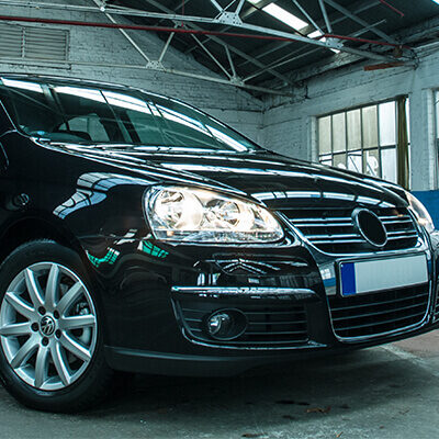 VW With Headlights on in Warehouse